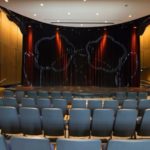 Interior view of Surrey Civic Theatres showing the Main Stage, seating area, and stage lighting, used by Surrey Speak to highlight upcoming theatre events.
