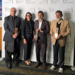 Award recipients and guests standing in front of the Dhahan Prize backdrop at the 2025 Punjabi Literature ceremony in Surrey, including author Balbir Parwana on the right.