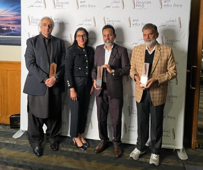 Award recipients and guests standing in front of the Dhahan Prize backdrop at the 2025 Punjabi Literature ceremony in Surrey, including author Balbir Parwana on the right.