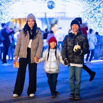 Surrey family enjoying the City of Surrey’s holiday light tunnel during winter festivities at Civic Plaza, photographed as part of Surrey’s seasonal events.