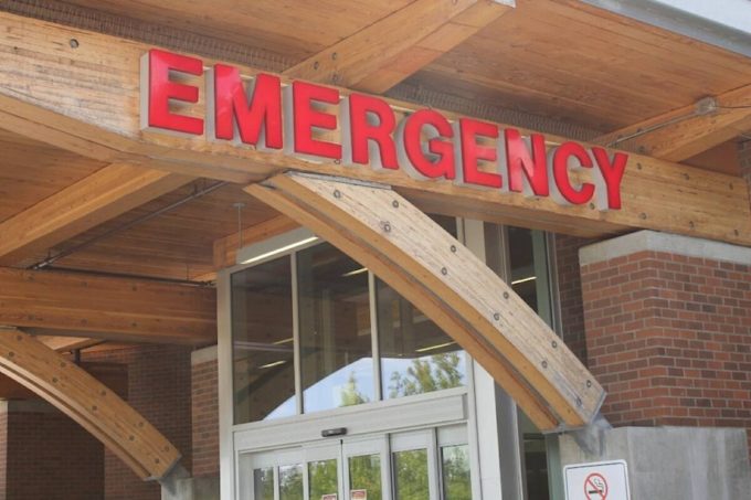 Entrance of a hospital emergency department in British Columbia, showing a red ‘Emergency’ sign above the doorway.