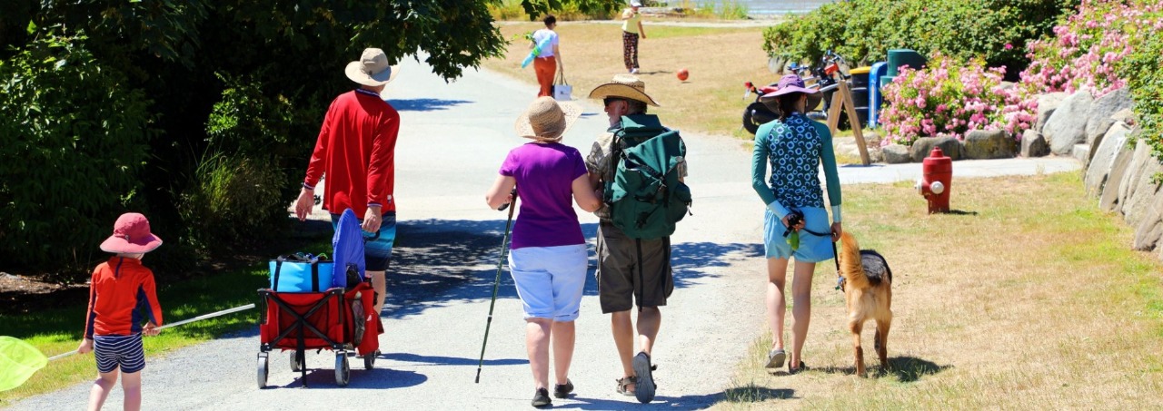 People walking along the main path at Crescent Beach in Surrey with a leashed dog, reflecting Surrey Speak coverage of the city’s new year-round dog access rules.