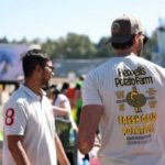A volunteer wearing a Heppell’s Potato Farm shirt hands out potatoes during an Ugly Potato Day event in South Surrey, supporting food security and featured by Surrey Speak.