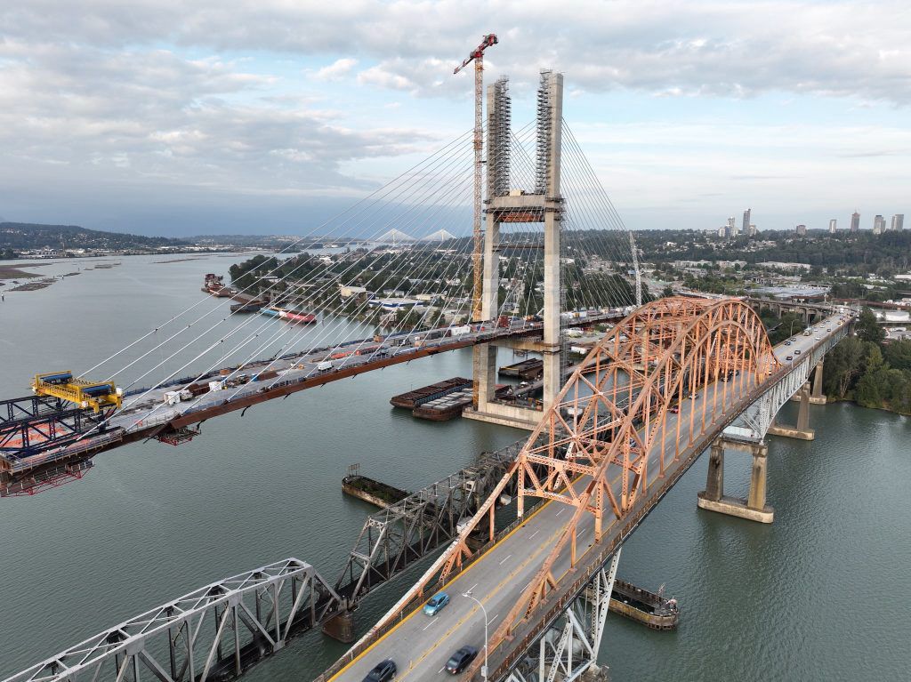 Aerial view of the new Pattullo Bridge replacement under construction beside the existing Pattullo Bridge over the Fraser River between Surrey and New Westminster.
