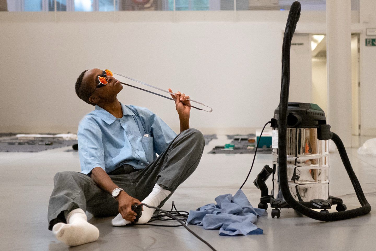 Performance artist Dana Michel interacts with office objects during a live presentation of MIKE at the Surrey Art Gallery.