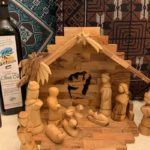 Handmade Palestinian olive-wood nativity set and olive oil bottles displayed at a South Surrey craft fair supporting West Bank artisans.