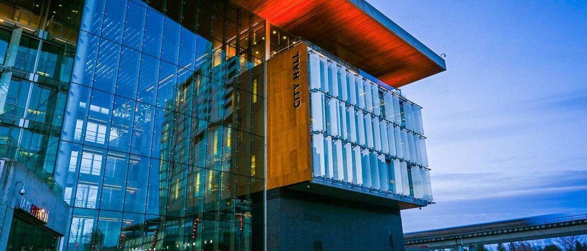 Surrey City Hall exterior at dusk, showing the glass façade and modern architecture associated with the city’s financial operations.