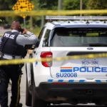 RCMP officer and police vehicle at a taped-off crime scene in Surrey during a homicide investigation.