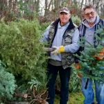 At the Semiahmoo Fish and Game Club last year, James Wilkins (left) and Chris Johnson (right) happily transferred donated Christmas trees from trunk to pile during their tree chipping event.