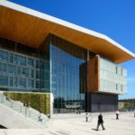 Exterior view of Surrey City Hall, showing the modern wood and glass facade with “City Hall” lettering.