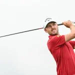 South Surrey golfer Adam Svensson follows through on a powerful tee shot while wearing a red shirt and white cap.