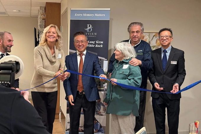 Officials and the first resident cut a blue ribbon during the opening ceremony for Bayview Seniors Community in White Rock.