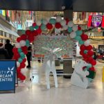 City Dream Centre’s Christmas display at North Surrey Secondary shows a balloon arch, holiday decorations and volunteers gathering for the Adopt a School project.