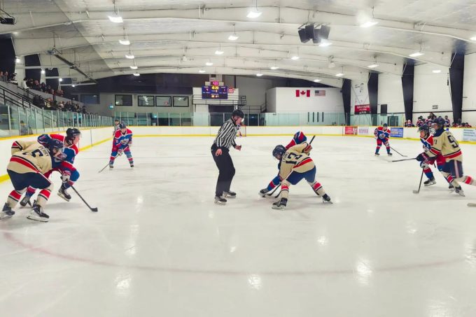 Cloverdale Hockey Club and Aldergrove Ironmen players battle for the puck during a faceoff in a PJHL game at Cloverdale Arena.