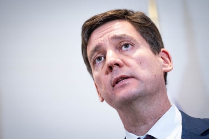 Close-up of B.C. Premier David Eby speaking at a news conference, with a neutral background.