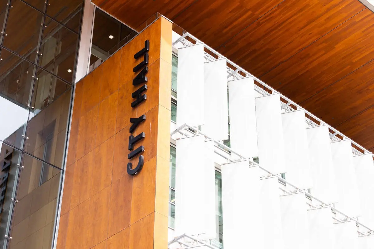 Exterior view of Surrey City Hall, showing the modern wood and glass facade with “City Hall” lettering.