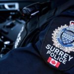 Close-up of a Surrey Police Service uniform patch inside a patrol vehicle, representing officers responding to a serious collision in Newton.