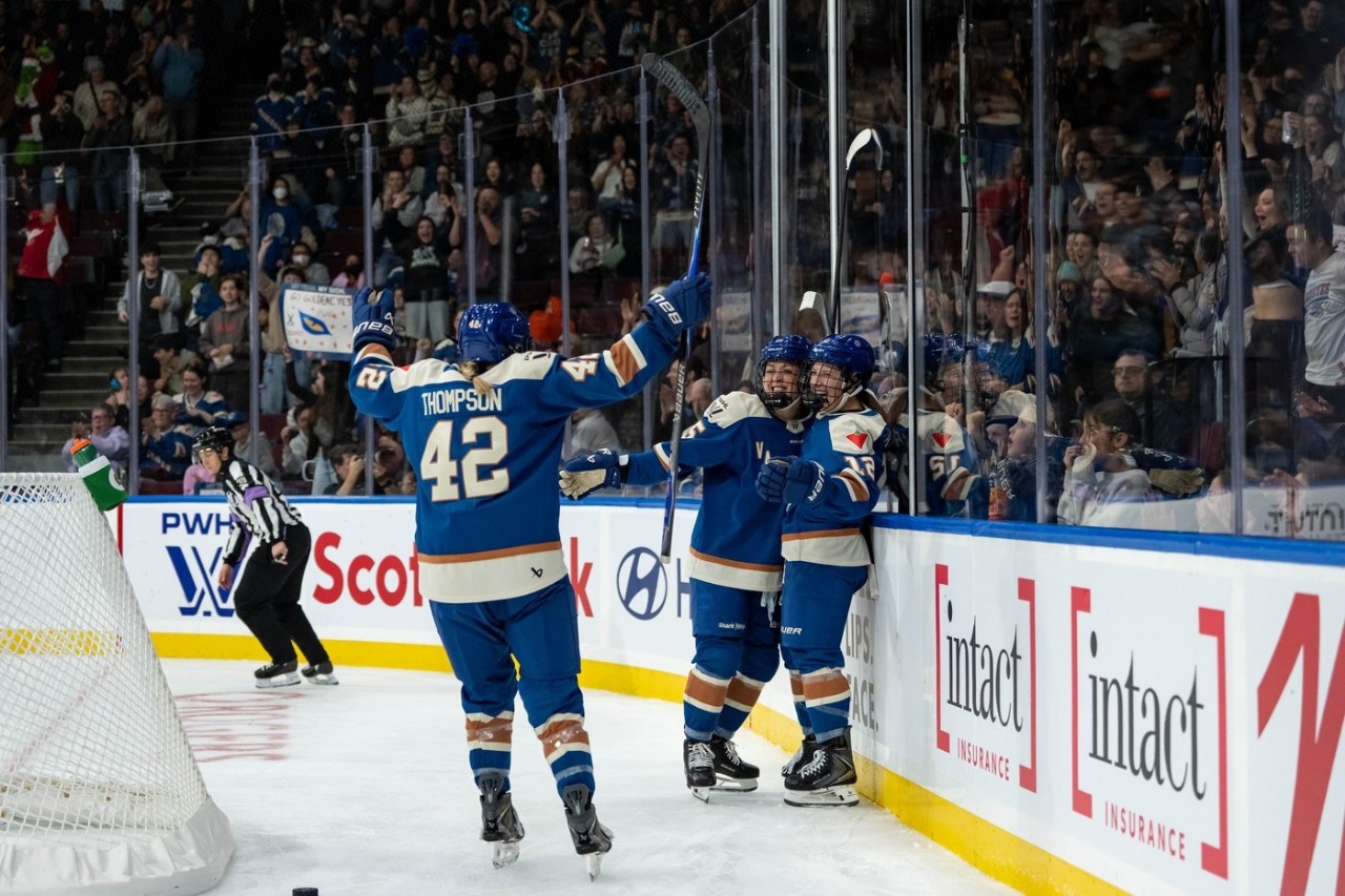 Vancouver Goldeneyes players celebrate a goal in front of a loud home crowd at Pacific Coliseum during their inaugural PWHL season.
