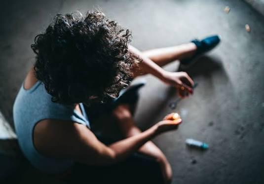 Person sitting on the floor showing signs of drug overdose amid British Columbia’s growing overdose crisis