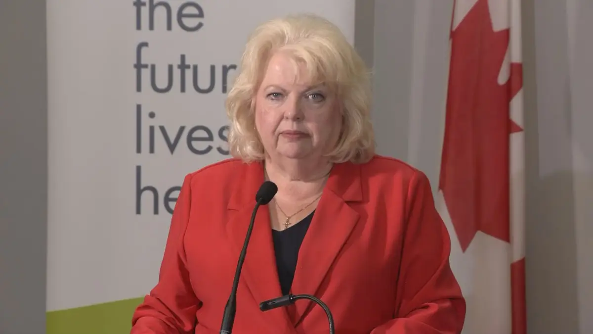 Surrey Mayor Brenda Locke speaks at a podium calling for federal action on extortion-related violence in Canada