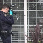 Police man taking pictures of fired marks