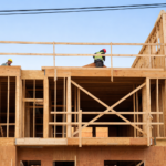 Construction workers on wooden building frame