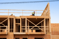 Construction workers on wooden building frame