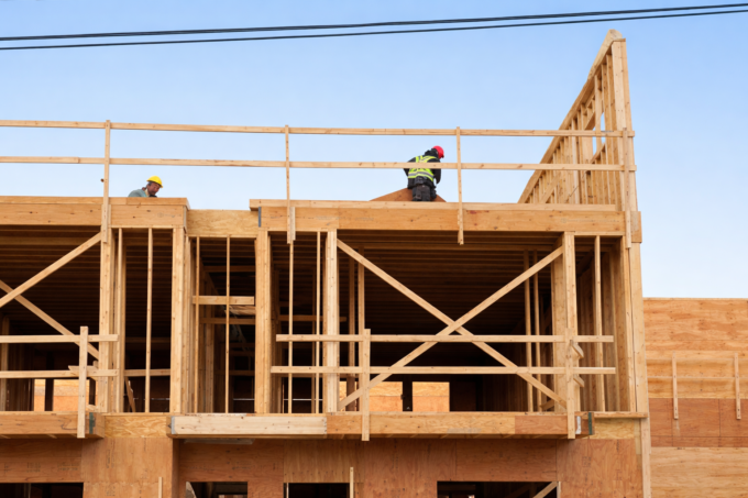 Construction workers on wooden building frame