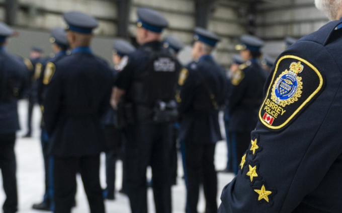 Surrey Police Service officers standing during a briefing at an indoor facility