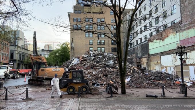 Memorial scene remembering victims of the Winters Hotel fire in Vancouver, with candles and community members gathered in reflection.