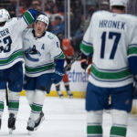 Vancouver Canucks players in action during an NHL game in California, competing against playoff-bound teams.