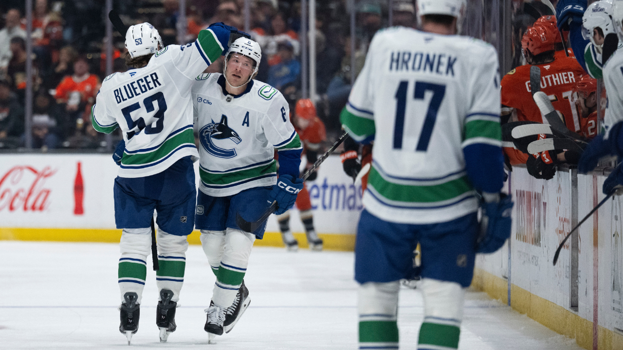 Vancouver Canucks players in action during an NHL game in California, competing against playoff-bound teams.