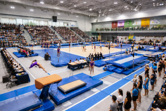 Gymnastics competition at Surrey sports complex with athletes and crowd