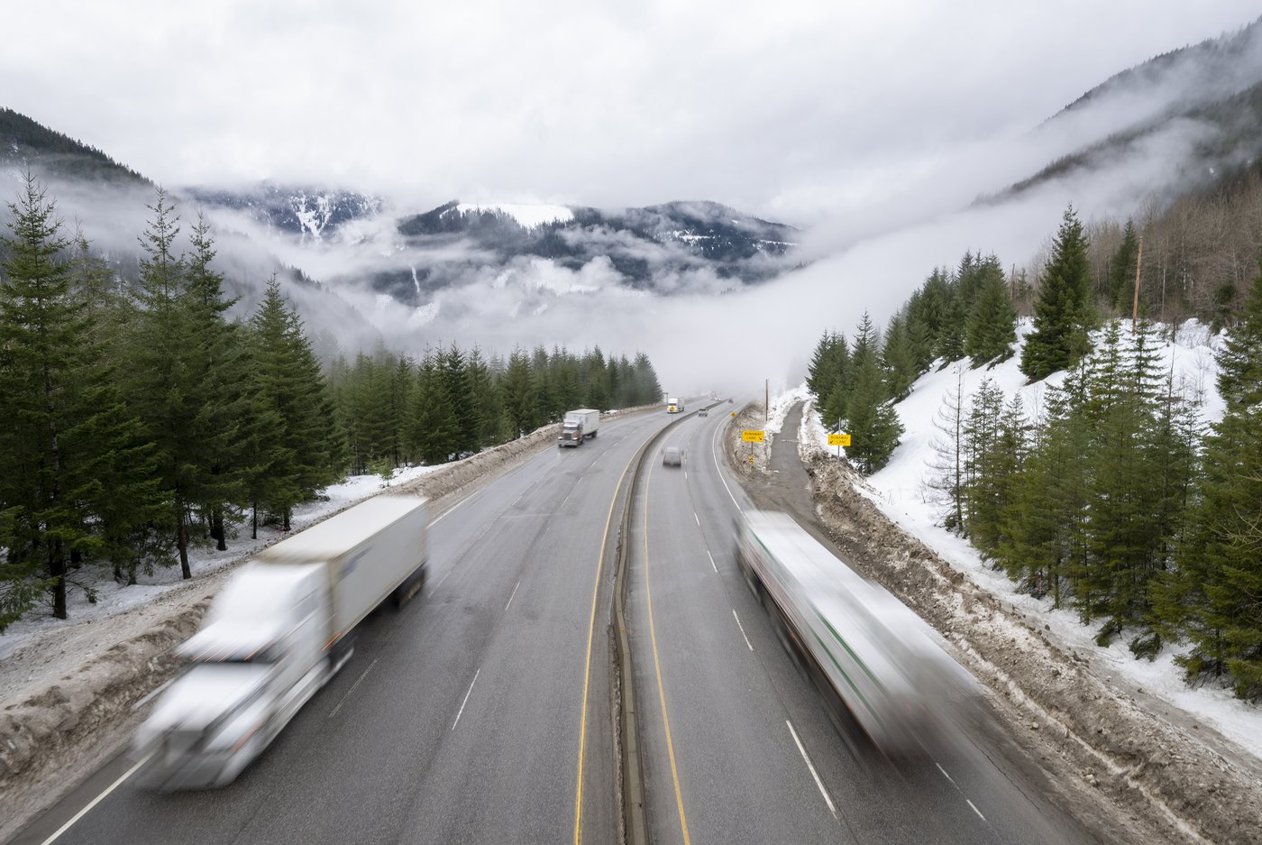 Snow-covered section of the Coquihalla Highway in British Columbia during winter driving conditions.
