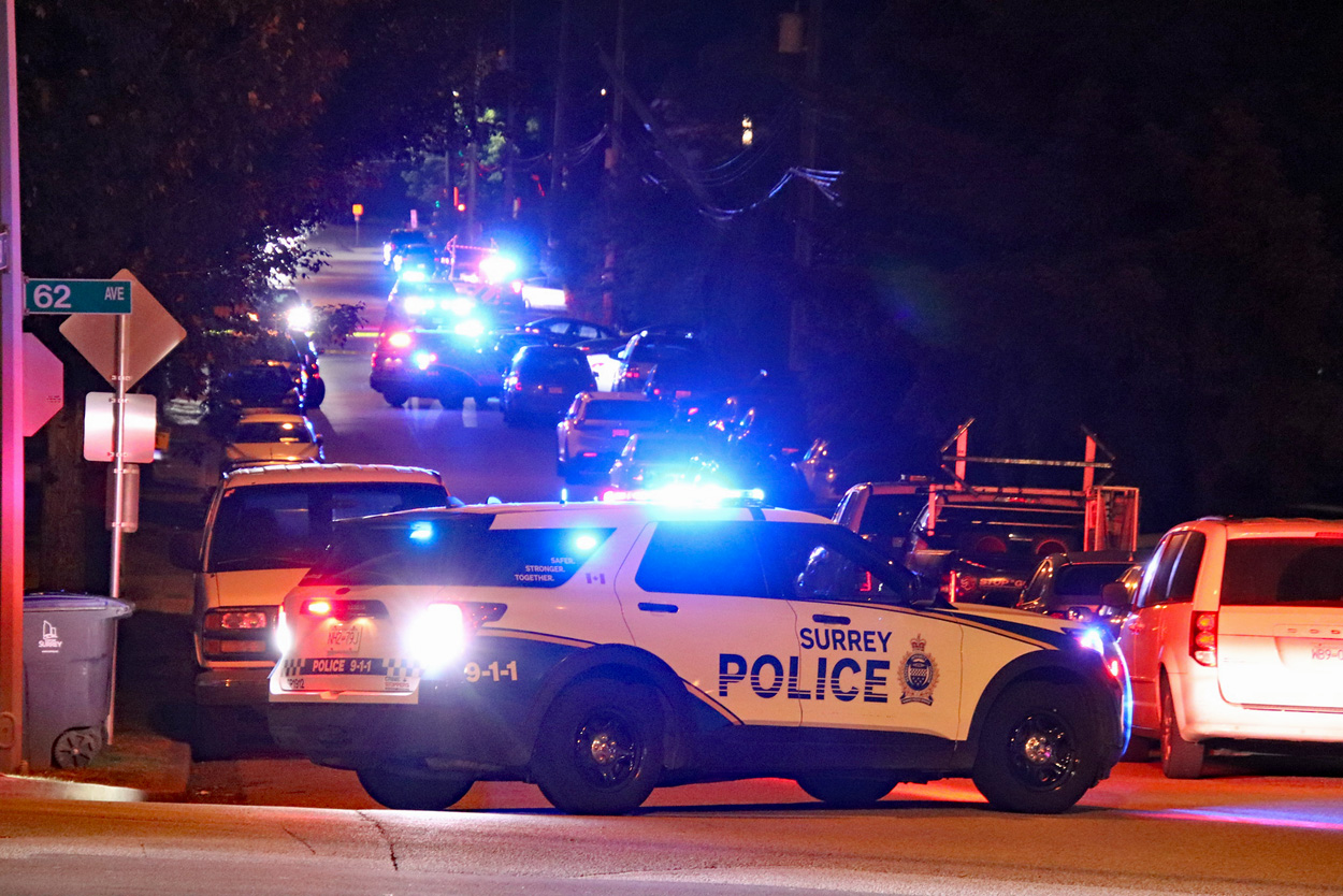 Police officers and emergency vehicles at the scene of a fatal shooting investigation in Surrey’s Newton neighbourhood.