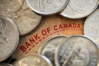 Worker holding cash while shopping in a grocery store in British Columbia.