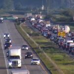 Emergency vehicles responding to a crash scene on Highway 99 in Surrey with heavy traffic nearby.