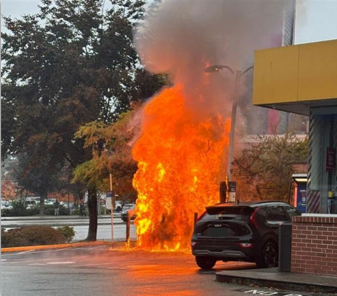 Technicians inspecting a damaged EV fast charging station after an electrical fire incident in British Columbia.