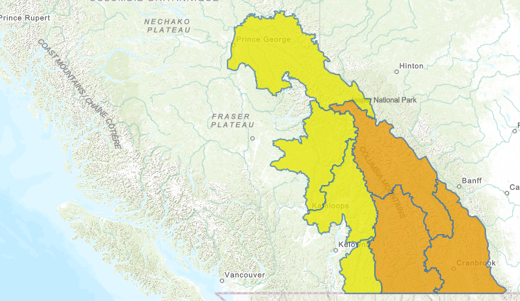 Dark storm clouds and heavy rain over southeastern British Columbia indicating flood watch conditions.
