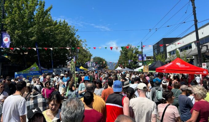 Large crowd attending Vancouver’s Italian Day festival with cultural decorations, food vendors, and entertainment.