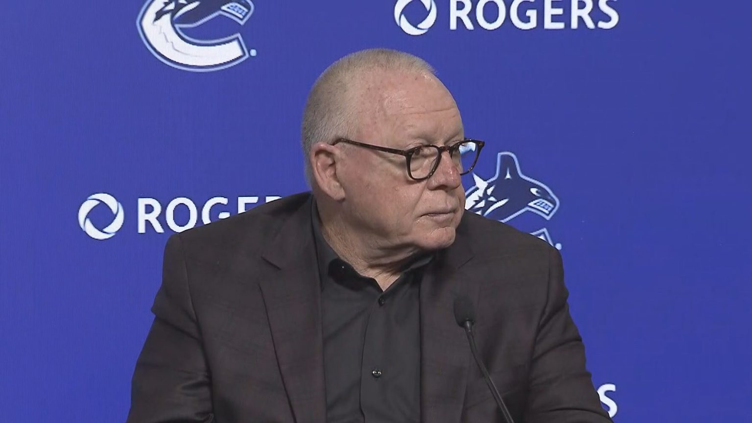 Vancouver Canucks branding and hockey atmosphere during a major organizational announcement.