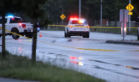 Police officers investigating a fatal pedestrian hit-and-run crash scene in Langley, British Columbia.