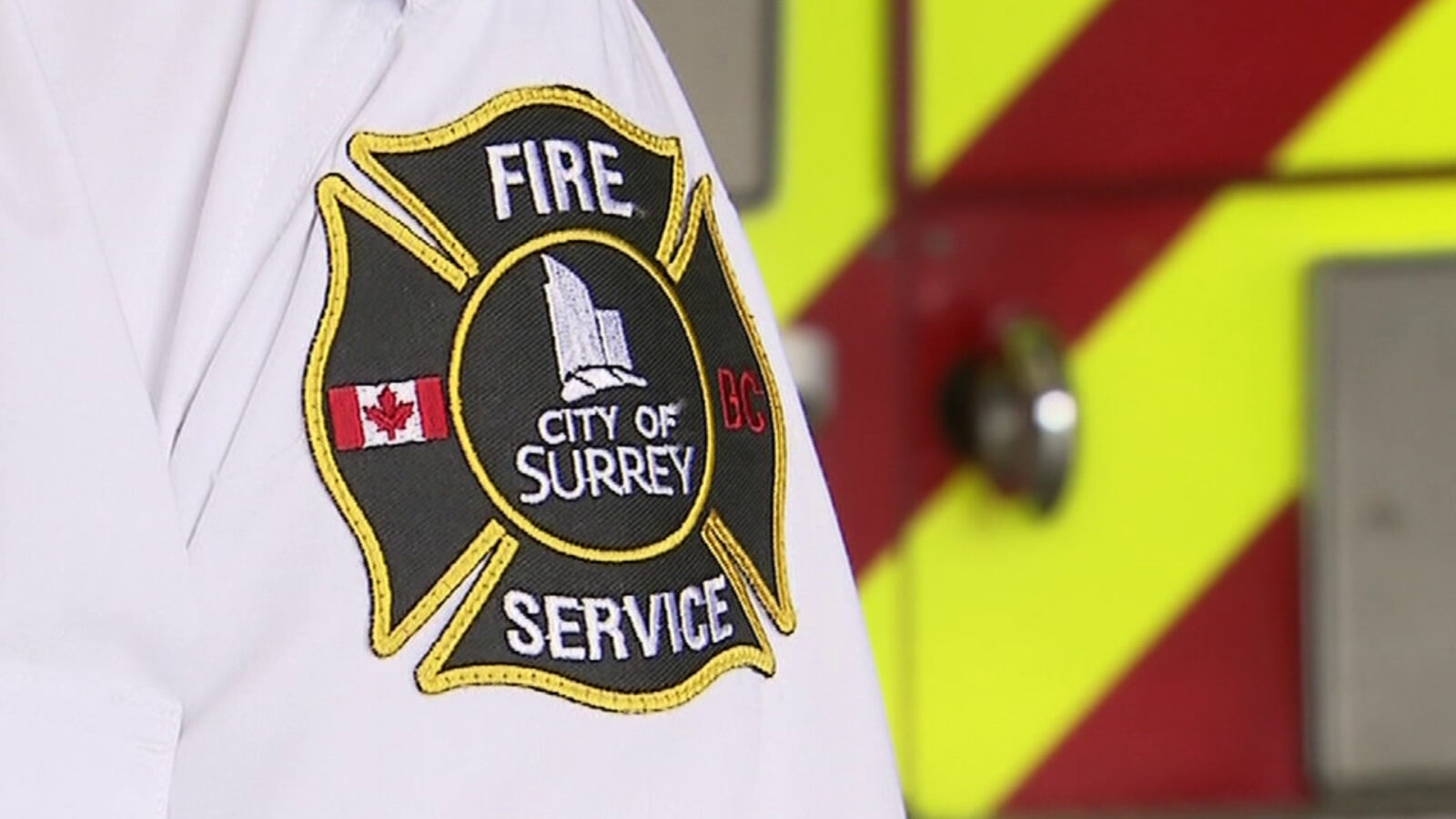 Firefighters responding to house fire in Surrey with smoke and emergency vehicles visible